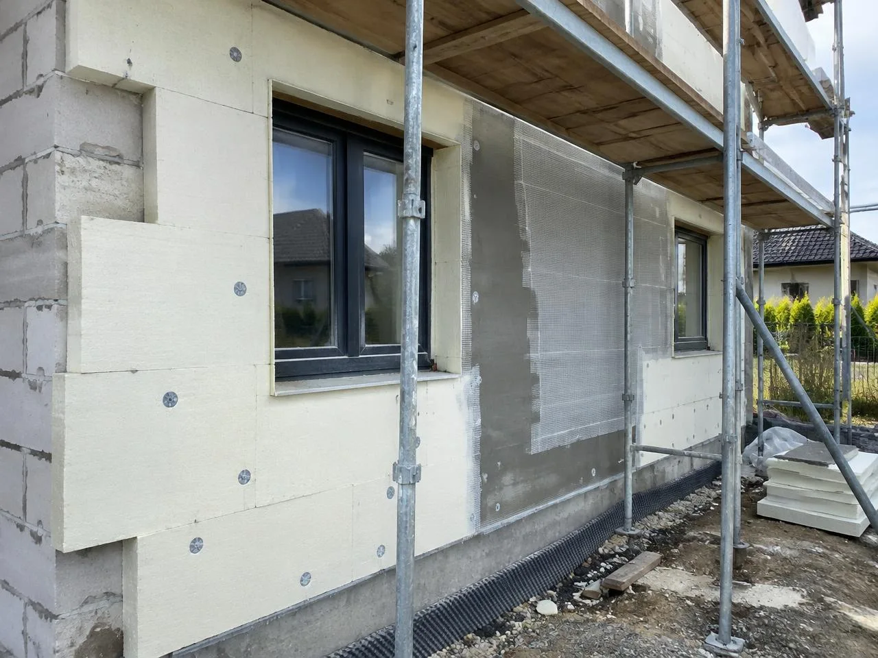 Dämmplatten an einer Hausfassade hinter einem Gerüst